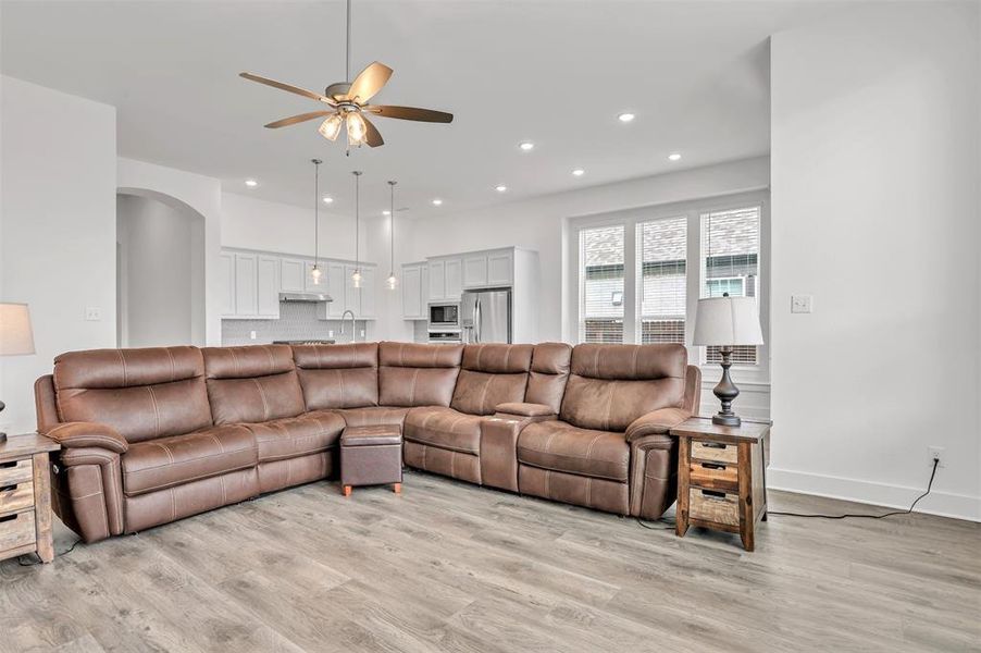 Living room with light hardwood / wood-style floors, sink, and ceiling fan