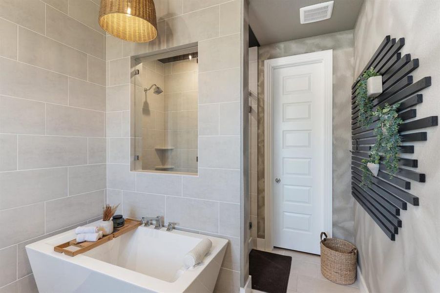 Bathroom with a bath to relax in, tile walls, and tile floors