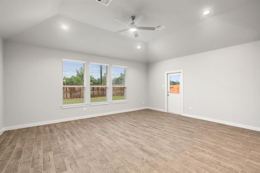 Family room flooded with natural light through the expansive windows. Sample photo of completed home with similar floor plan. As-built interior colors and selections may vary.