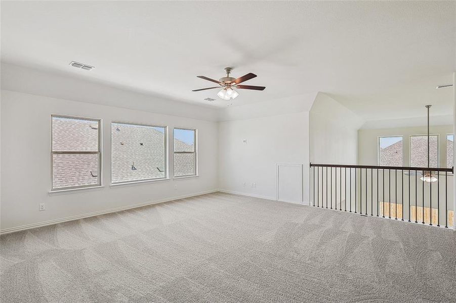 Carpeted spare room with ceiling fan