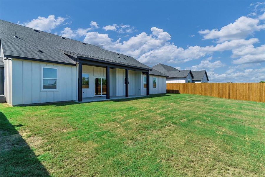 Rear view of house featuring a lawn