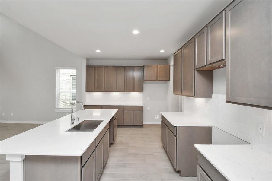 Culinary haven, featuring granite countertops, a tile backsplash, stainless steel appliances (to be installed), and 42” upper cabinets.