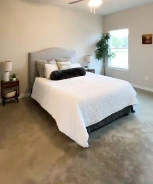 Carpeted bedroom featuring ceiling fan