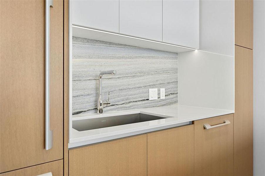 Sleek cabinets provide ample storage space while maintaining a clean and minimalist aesthetic. The kitchen's design is further enhanced by high-quality materials and finishes, elevating the overall ambiance.