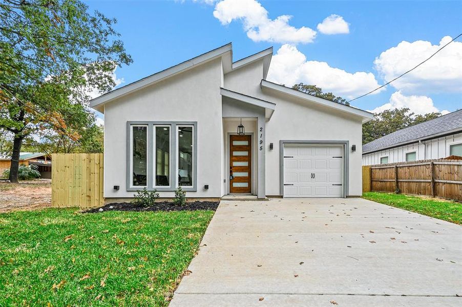 View of front of house with a front yard and a one-car garage