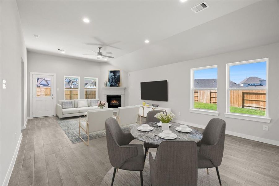 Take another glimpse into the heart of the home with this view of the dining area and family room—a sprawling space ready to accommodate all your gatherings. Sample photo of completed home with similar floor plan. As-built interior colors and selections may vary.