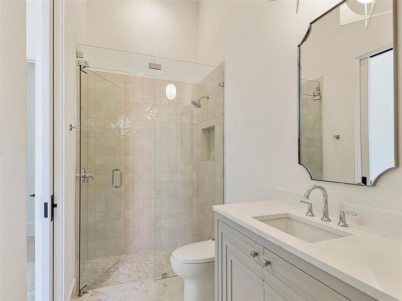 Bathroom with a shower with door, vanity, and toilet