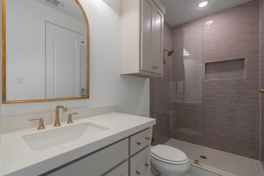 Bathroom with a shower with shower door, toilet, and vanity