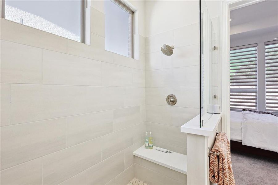 Bathroom featuring tiled shower and a wealth of natural light