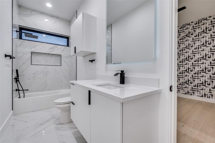 Full bathroom featuring tiled shower / bath, vanity, hardwood / wood-style floors, and toilet