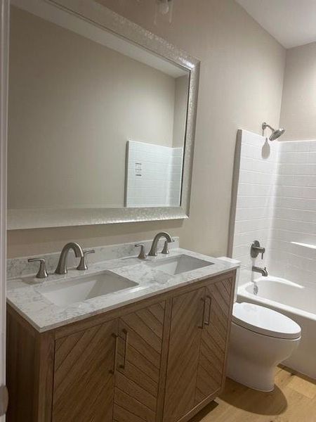 Full bathroom featuring shower / tub combination, vanity, toilet, and hardwood / wood-style flooring