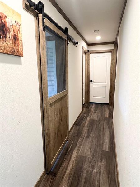 Hall featuring crown molding, dark hardwood / wood-style flooring, and a barn door