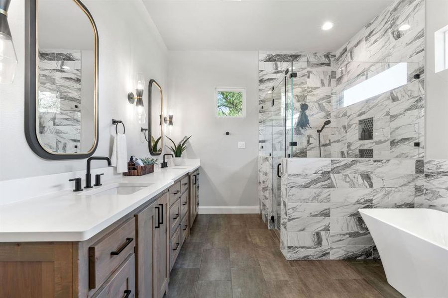 Bathroom featuring dual bowl vanity, hardwood / wood-style flooring, and separate shower and tub