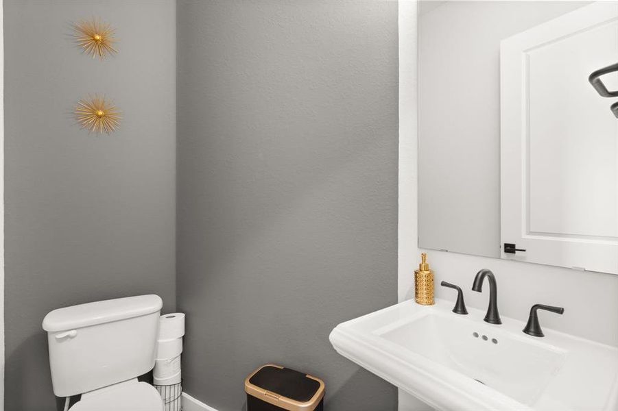 The half bathroom features a toilet and sink, offering convenient amenities in a compact space.