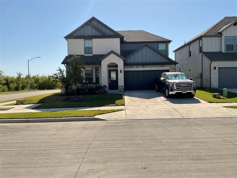 View of front of property with a front yard and a garage