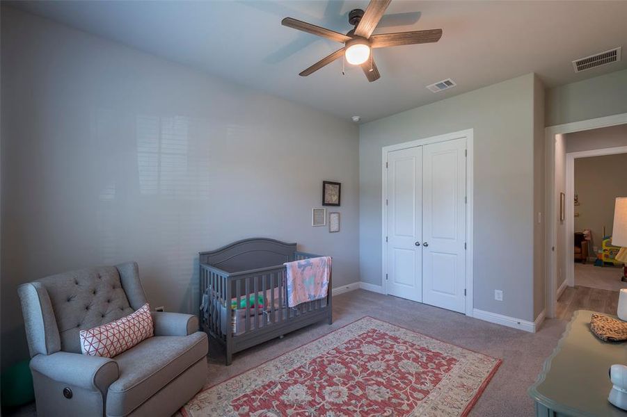 A view of the double door closet and the adjacent secondary bedroom with a full bath in between.