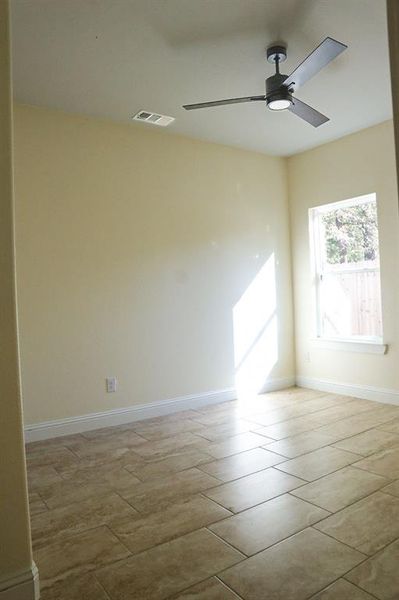 Empty room with light tile patterned flooring and ceiling fan