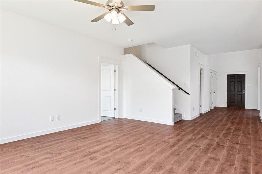 Unfurnished living room with ceiling fan and wood-type flooring