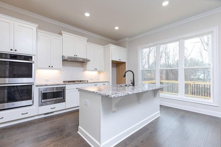 The open concept design of the kitchen creates a seamless flow between the kitchen, and family room.   Photo not actual home, but previously built Mansfield plan.