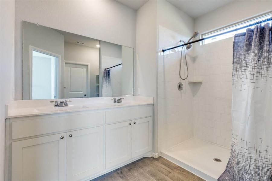 Bathroom featuring hardwood / wood-style flooring, vanity, and a shower with curtain