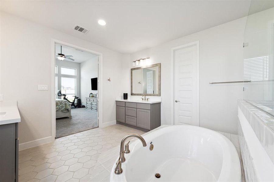 The primary bath has a custom ceramic tile floor, recessed lighting and double closets.