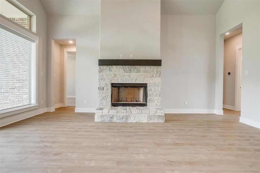 Unfurnished living room with a fireplace and light wood-type flooring
