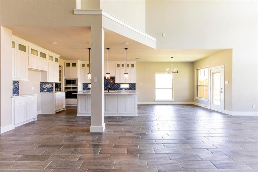 Kitchen featuring white cabinets, tasteful backsplash, appliances with stainless steel finishes, and a kitchen island