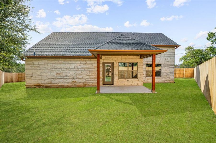 Rear view of property with a lawn and a patio area