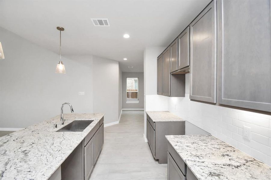 Discover another perspective of this stunning kitchen, generously appointed with an abundance of counter space. Sample photo of completed home with similar floor plan. Actual colors and selections may vary.