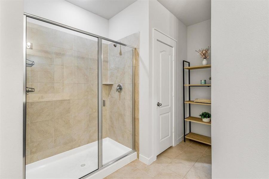 Bathroom featuring a shower with door and tile patterned floors