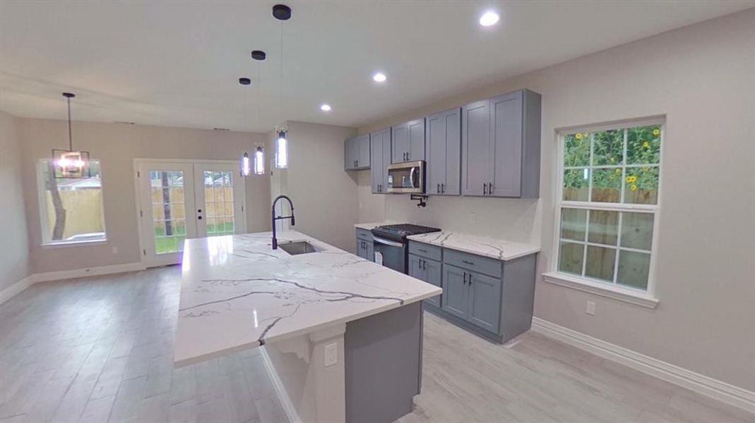 Welcome to 8125 Venus St bright open kitchen island. (Picture is of a finished home.)