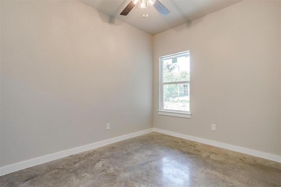 Empty room with ceiling fan and concrete flooring