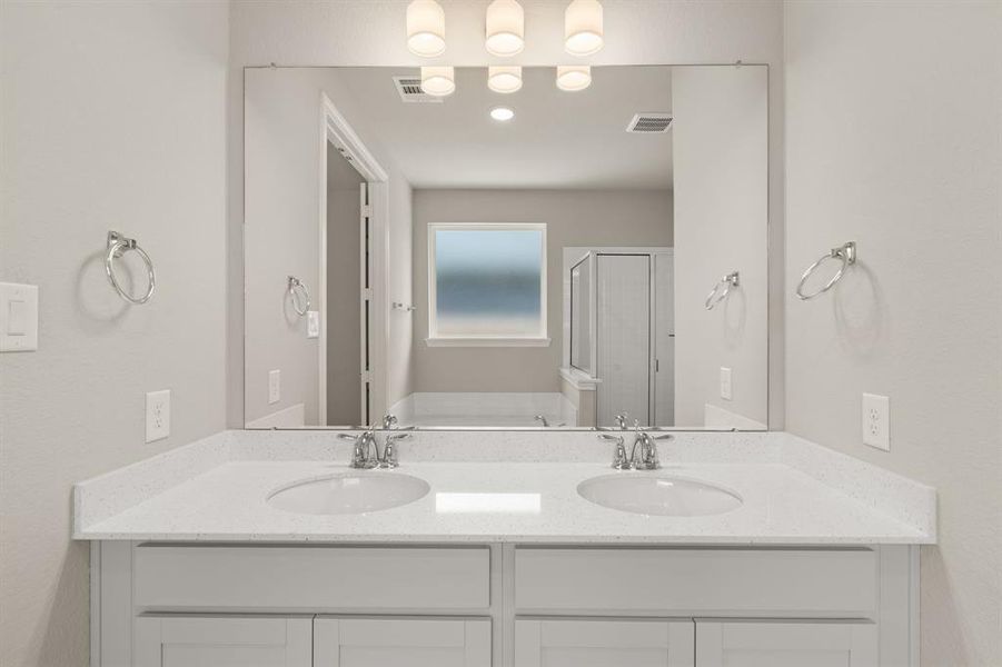 The en-suite bathroom offers a spa-like atmosphere with its elegant design, high end finishes, and tasteful lighting, creating a retreat within your own home.