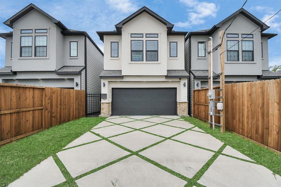 Exterior Front, the patchwork astroturf elongates the driveway, and the two-car garage behind door.