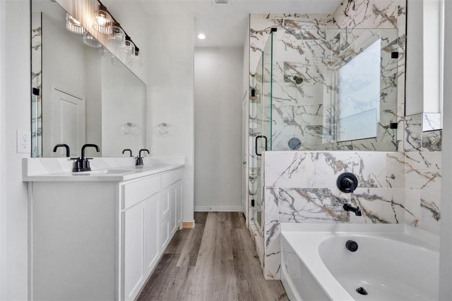 Bathroom featuring dual bowl vanity, separate shower and tub, and hardwood / wood-style floors