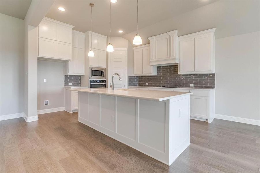 Kitchen featuring white cabinetry, a center island with sink, and appliances with stainless steel finishes