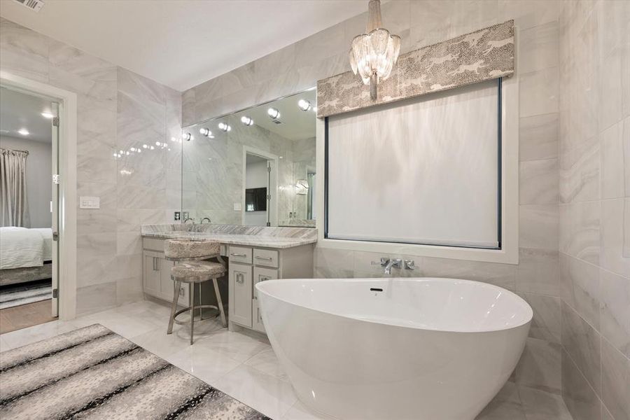 Bathroom featuring tile walls, a bathing tub, and vanity