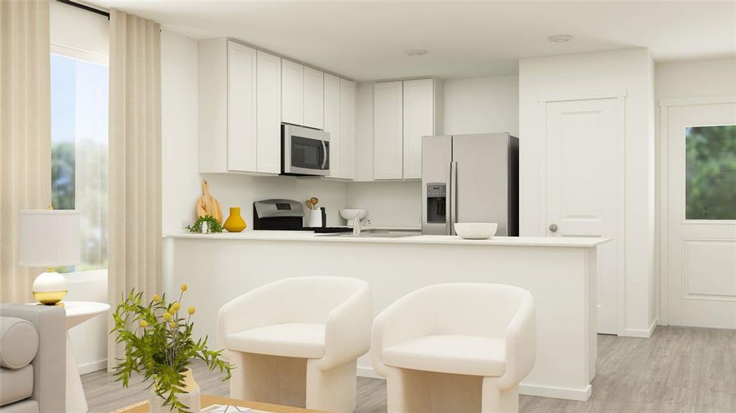 Kitchen featuring white cabinets, kitchen peninsula, appliances with stainless steel finishes, a breakfast bar, and light hardwood / wood-style floors