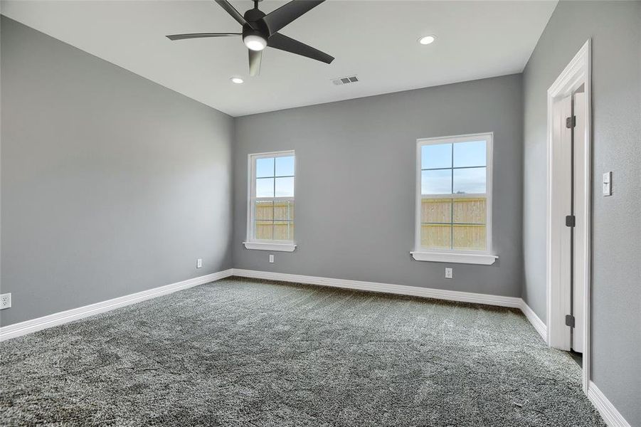 Carpeted empty room featuring ceiling fan