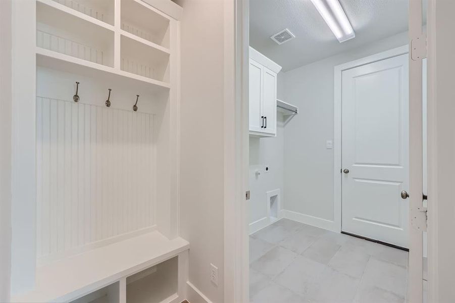 Mudroom with light tile patterned floors