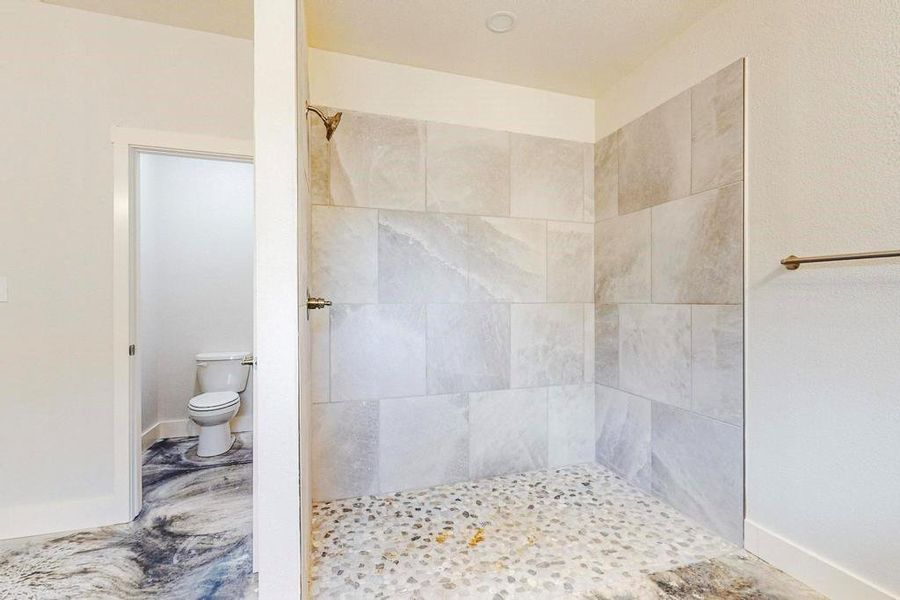 Bathroom with toilet and tiled shower