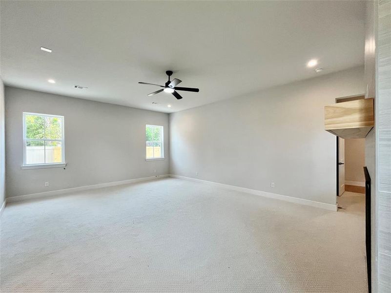 Carpeted empty room featuring ceiling fan