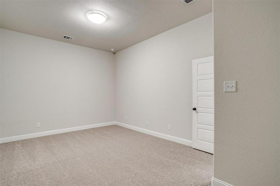 Carpeted spare room featuring a textured ceiling