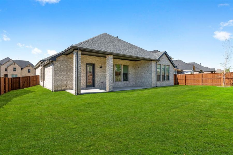 Back of property with a yard and a patio