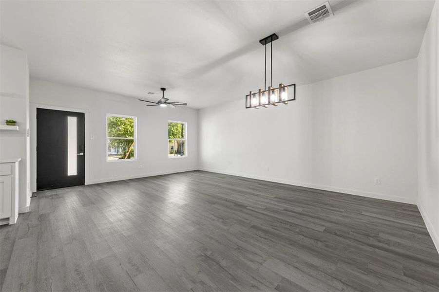 Kitchen with a center island with sink, wall chimney range hood, light hardwood / wood-style floors, and white cabinets