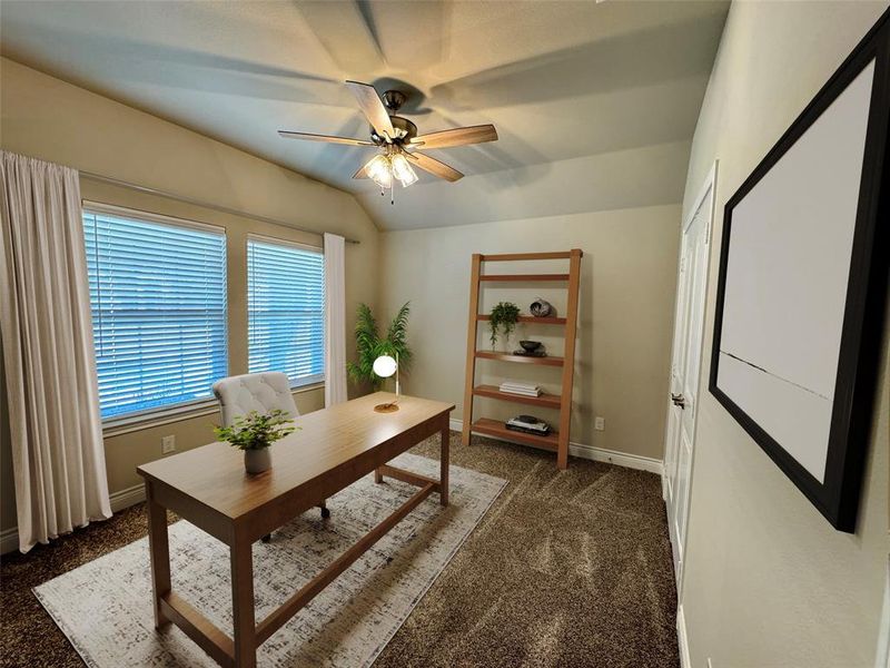 Office space with dark carpet, ceiling fan, and lofted ceiling