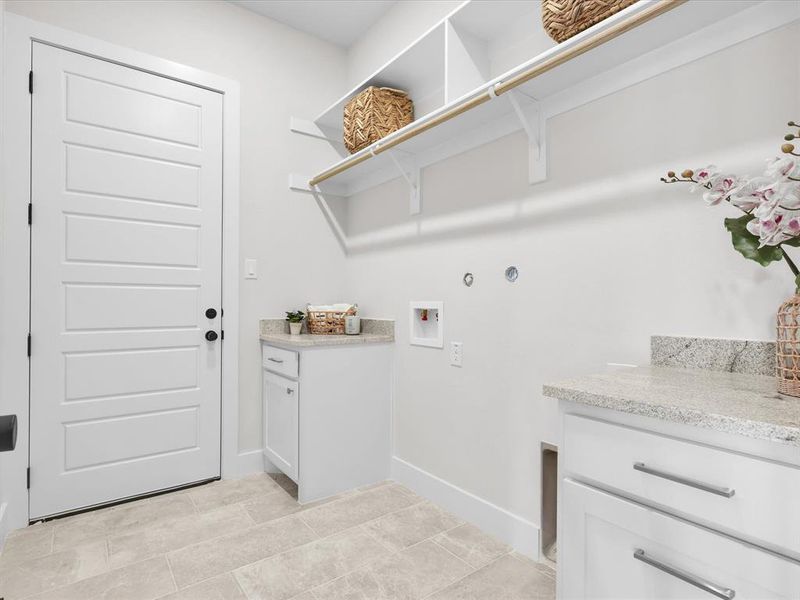 Washroom featuring cabinets, light tile patterned floors, and washer/dryer hookups