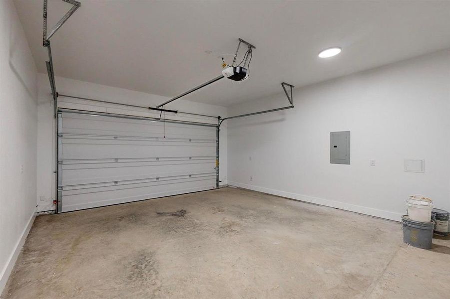 Garage featuring a garage door opener and electric panel