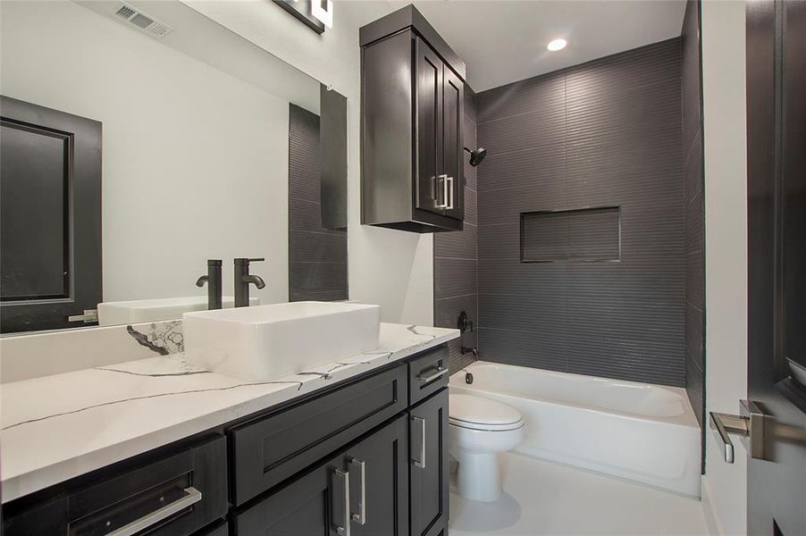 Full bathroom featuring bathing tub / shower combination, toilet, and vanity