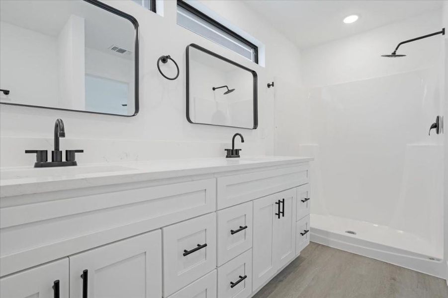 Bathroom with vanity, hardwood / wood-style flooring, and a shower